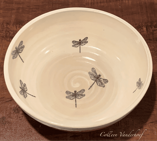 Cream-colored ceramic bowl with black dragonfly illustrations inside.
